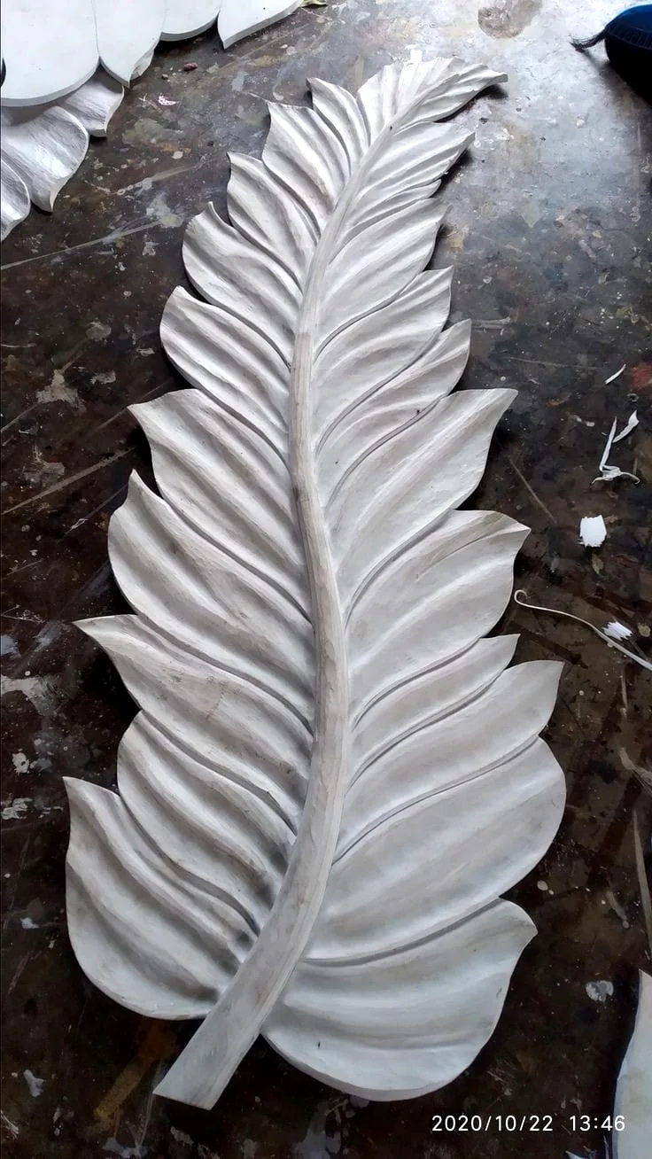 A single oversized white feather sculpted in relief