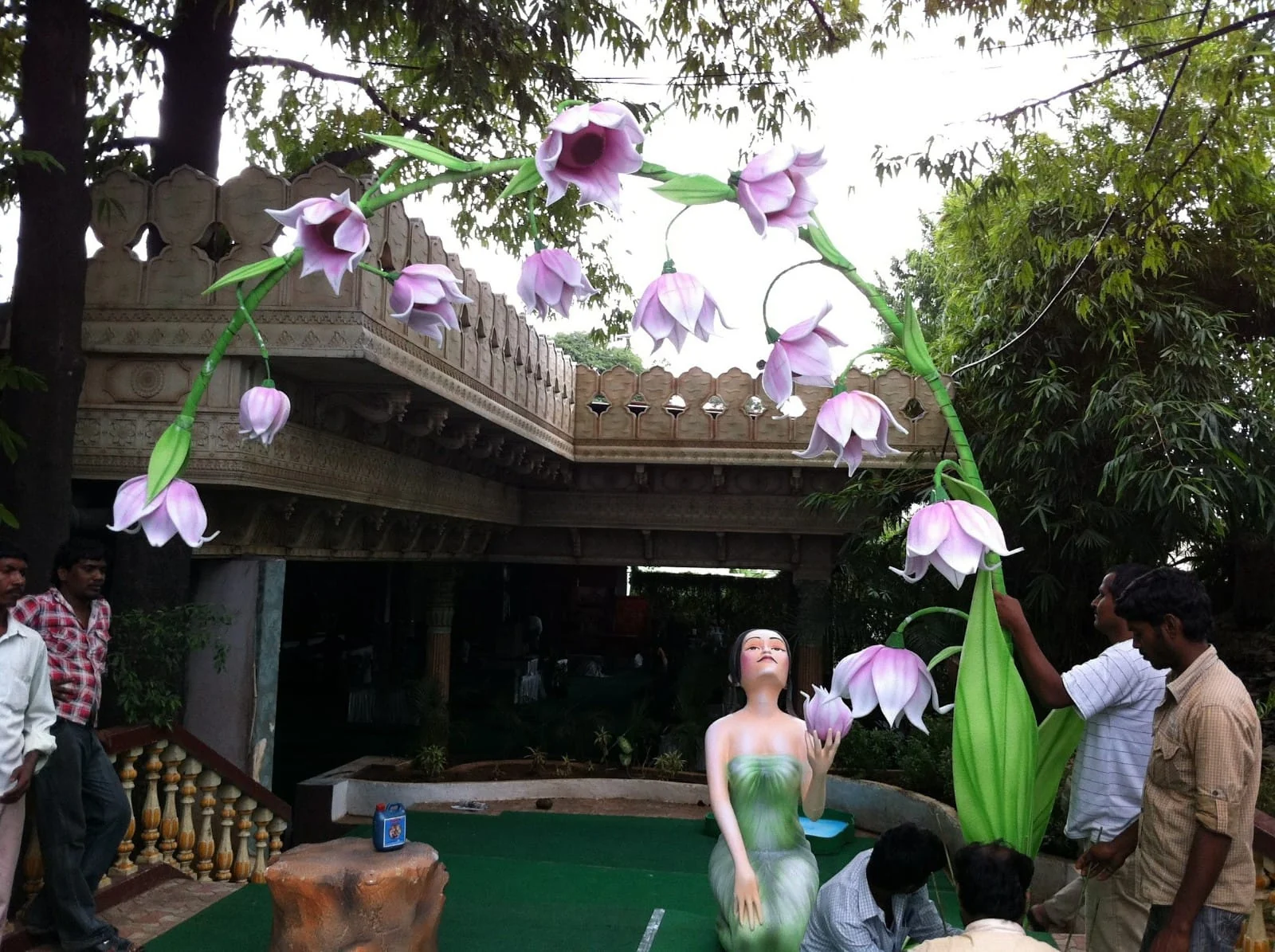 Outdoor floral arch with oversized purple flowers and a fairy character