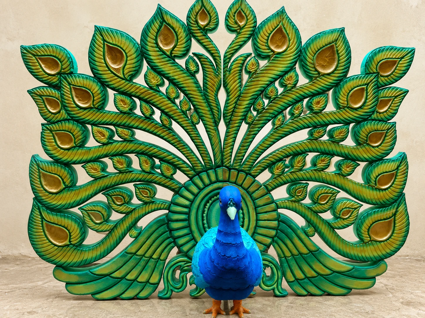 Large blue and green peacock sculpture with a fan of individually detailed feathers