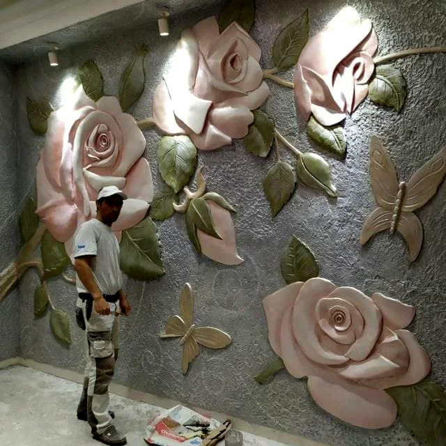 Large pink rose wall relief with butterflies and leaves, finished in soft tones over a textured grey wall